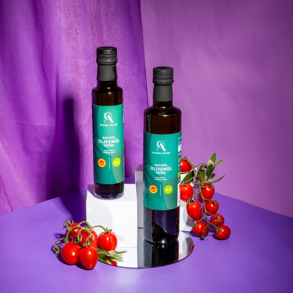 Aroma Olymp Bio Olivenöl nativ extra aus Kreta g. U. 250 ml – zwei Flaschen mit Tomaten auf lila Hintergrund arrangiert